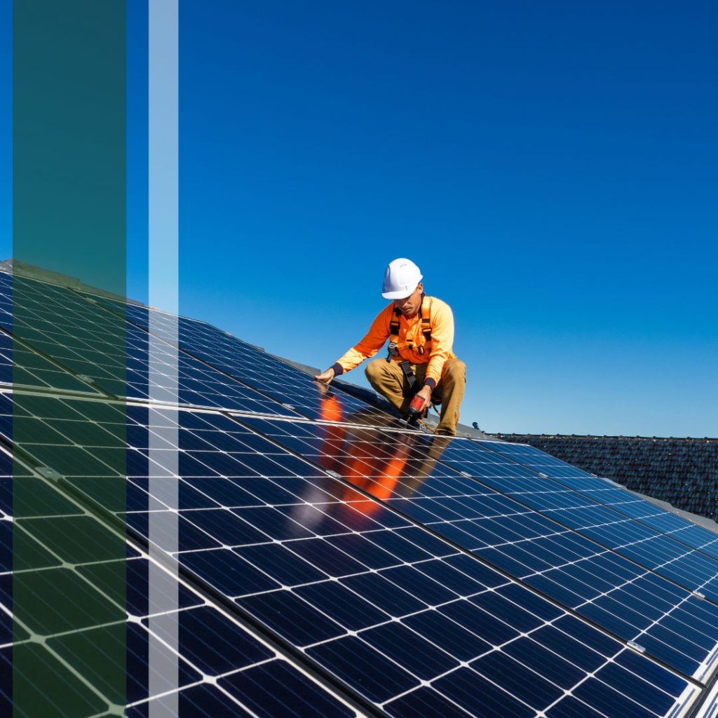 A worker squatting next to solar panels