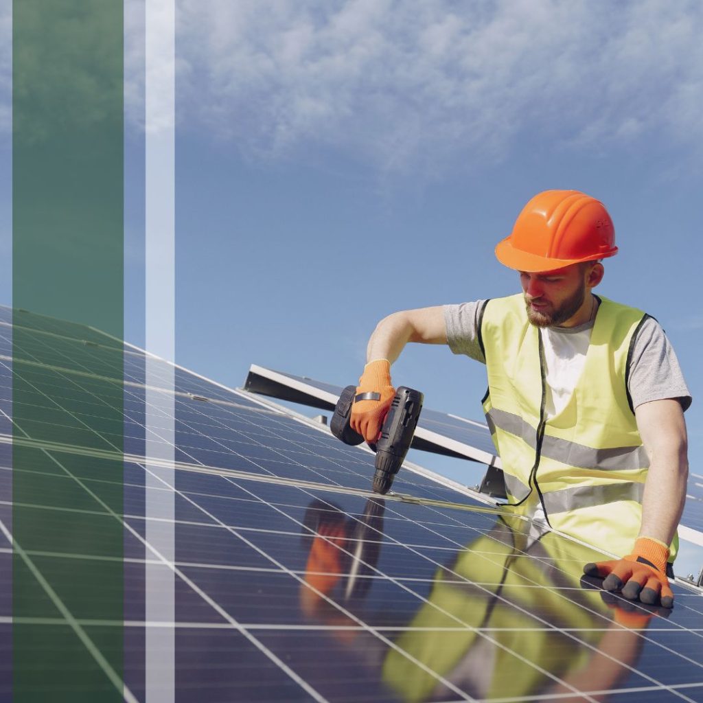 Solar worker drilling on a panel