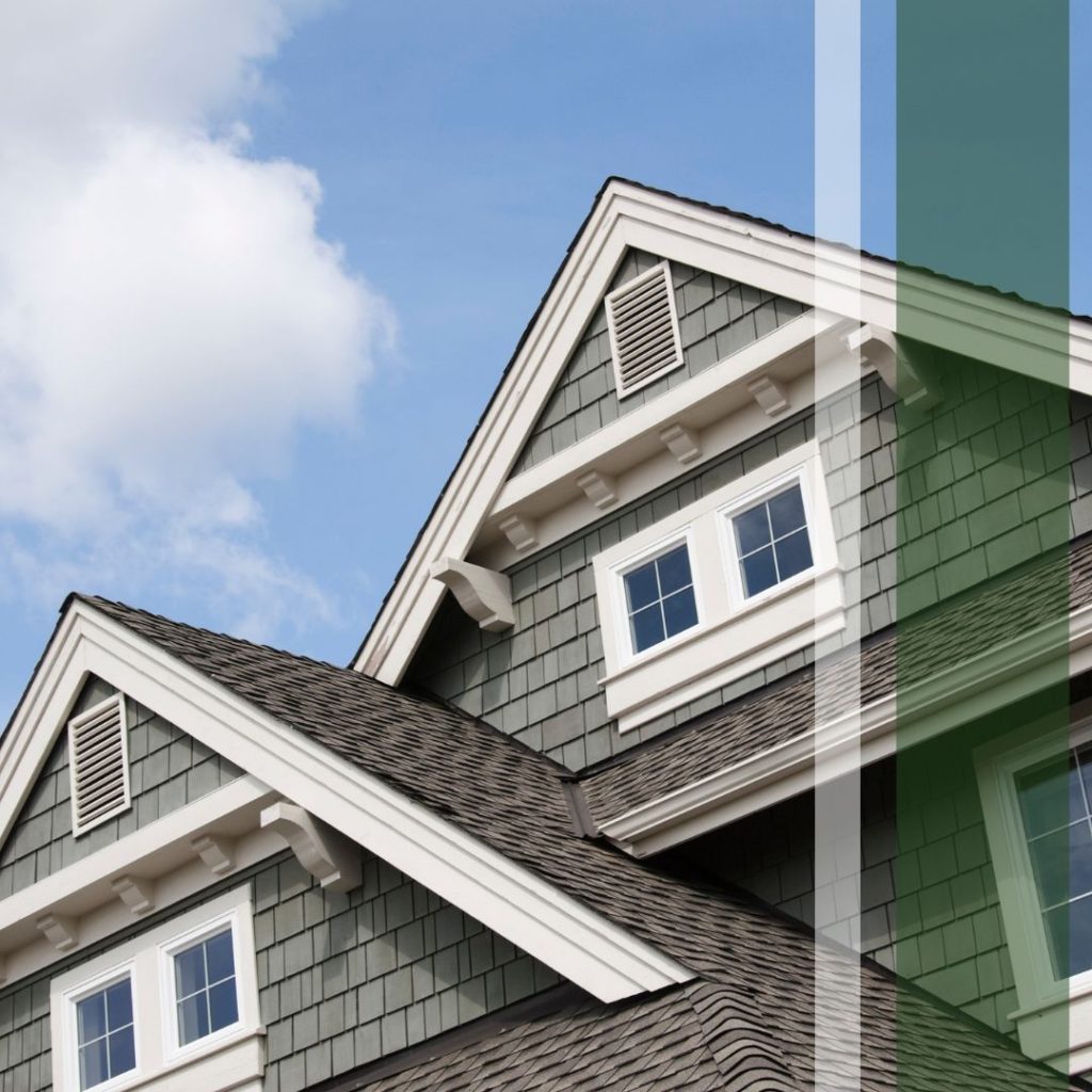 A view of the upper level of a nice home with some roofing in the foreground