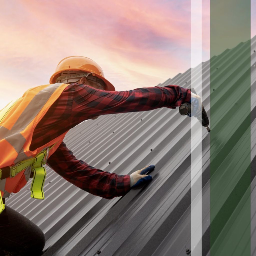 A worker in safety gear using a drill on a metallic roof