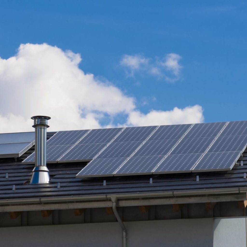 Solar panels on a roof around a chimney